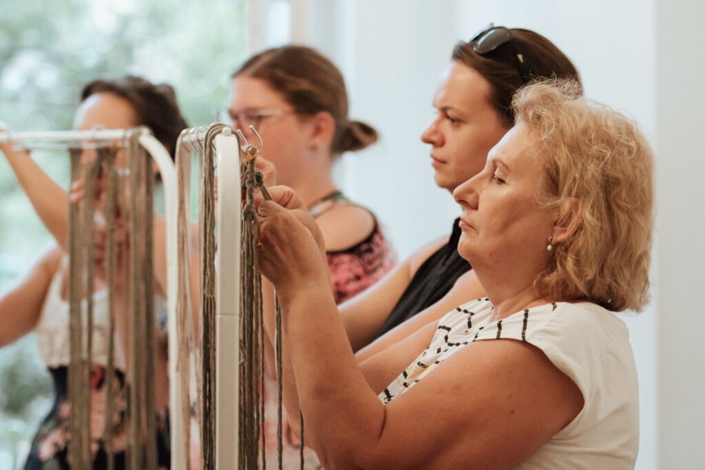 A workshop résztvevői elmélyülten makraméznak.